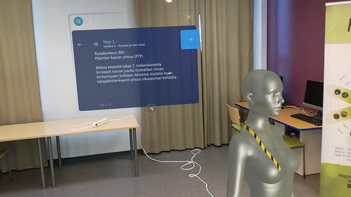 VR näkymä holotekstistä ja mallinukesta luokkatilassa